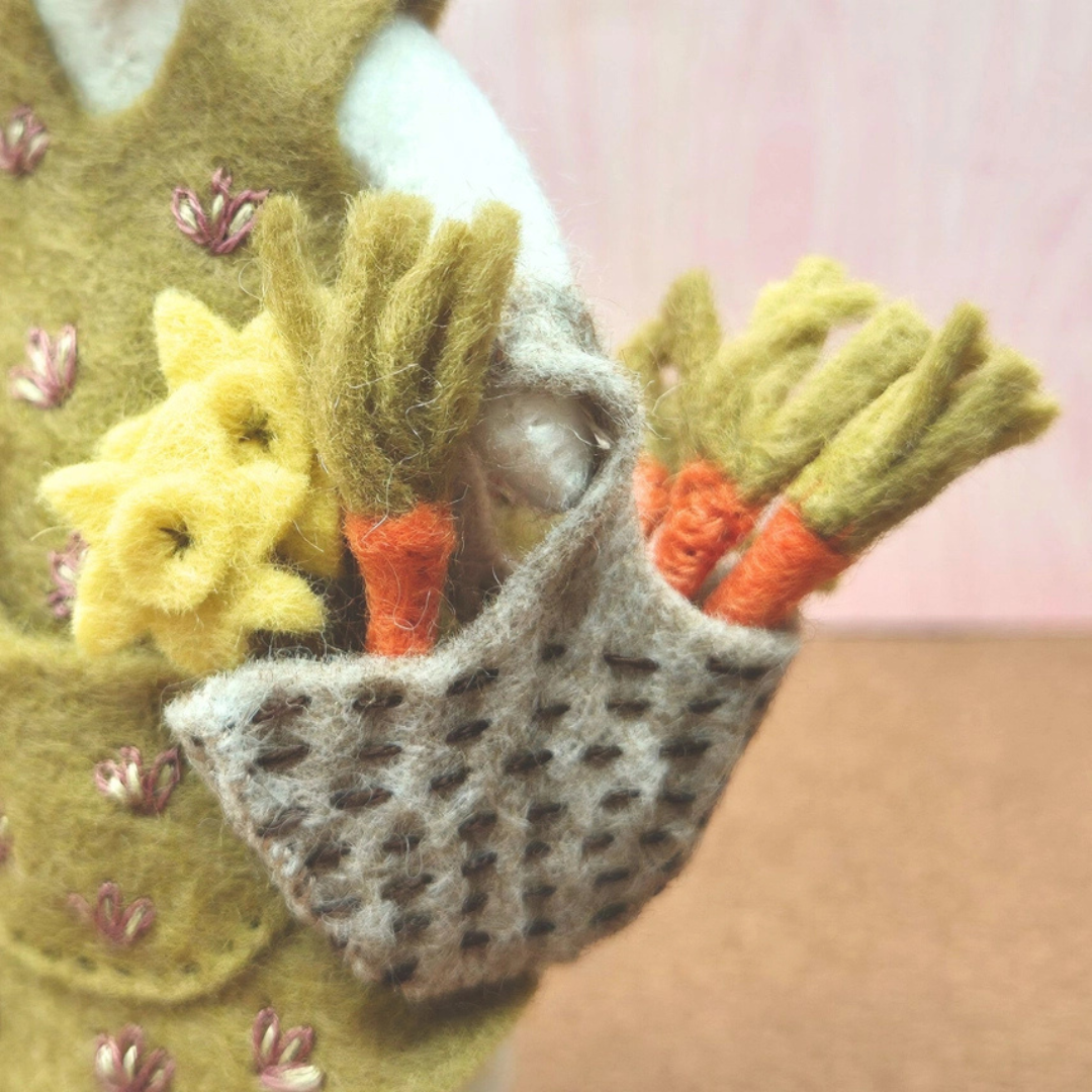 Close-up of the felt mouse gardener’s woven basket filled with handmade carrots, leeks and garden produce.