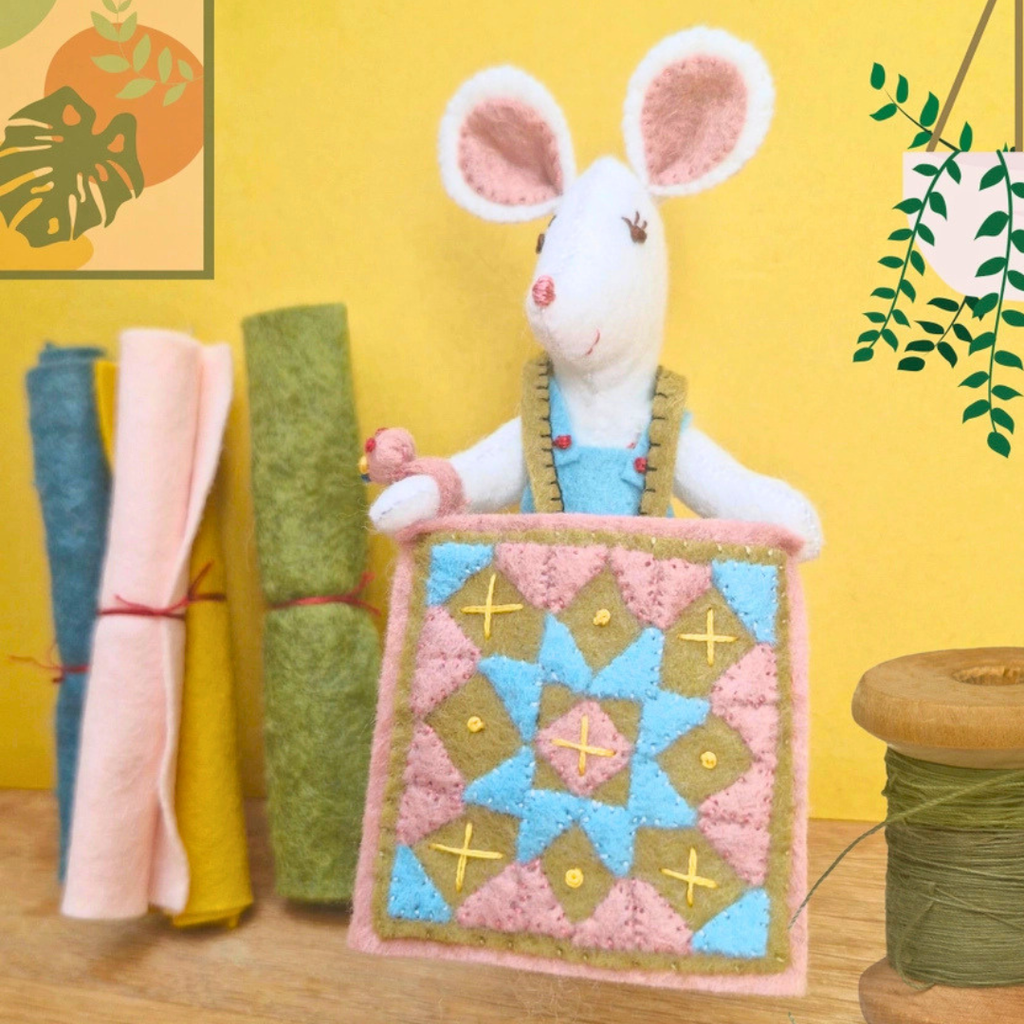 Completed Little Mouse The Quilter displayed with her colourful patchwork quilt and coordinating pieces of felt.