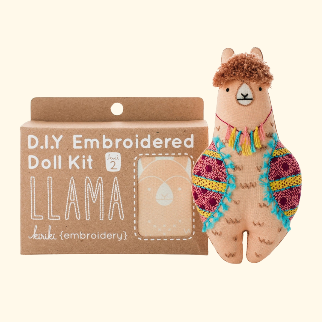 Llama Embroidery Kit by Kiriki Press shown with the completed embroidered doll and packaging.