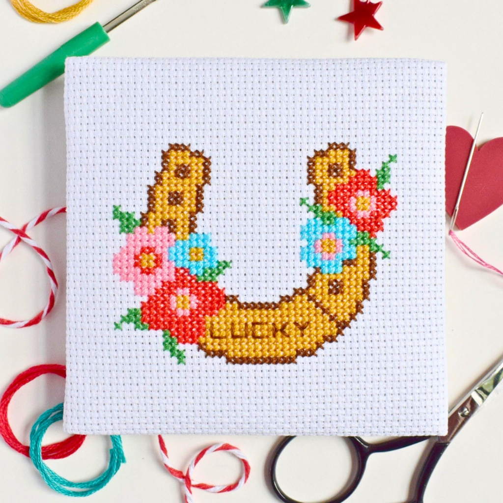 Lucky Horseshoe Mini Cross Stitch Kit in progress stitched on white Aida fabric.