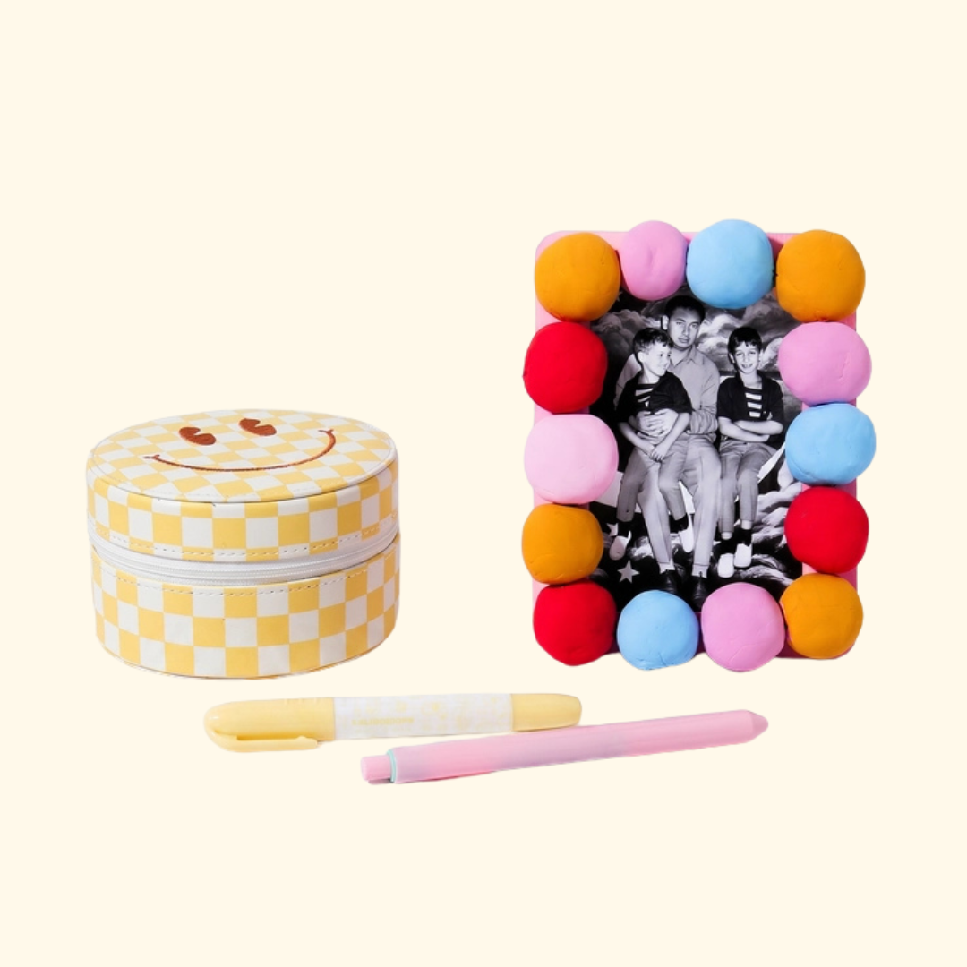 Completed air dry clay photo frame decorated with colourful clay balls alongside the included paintbrush and tools.