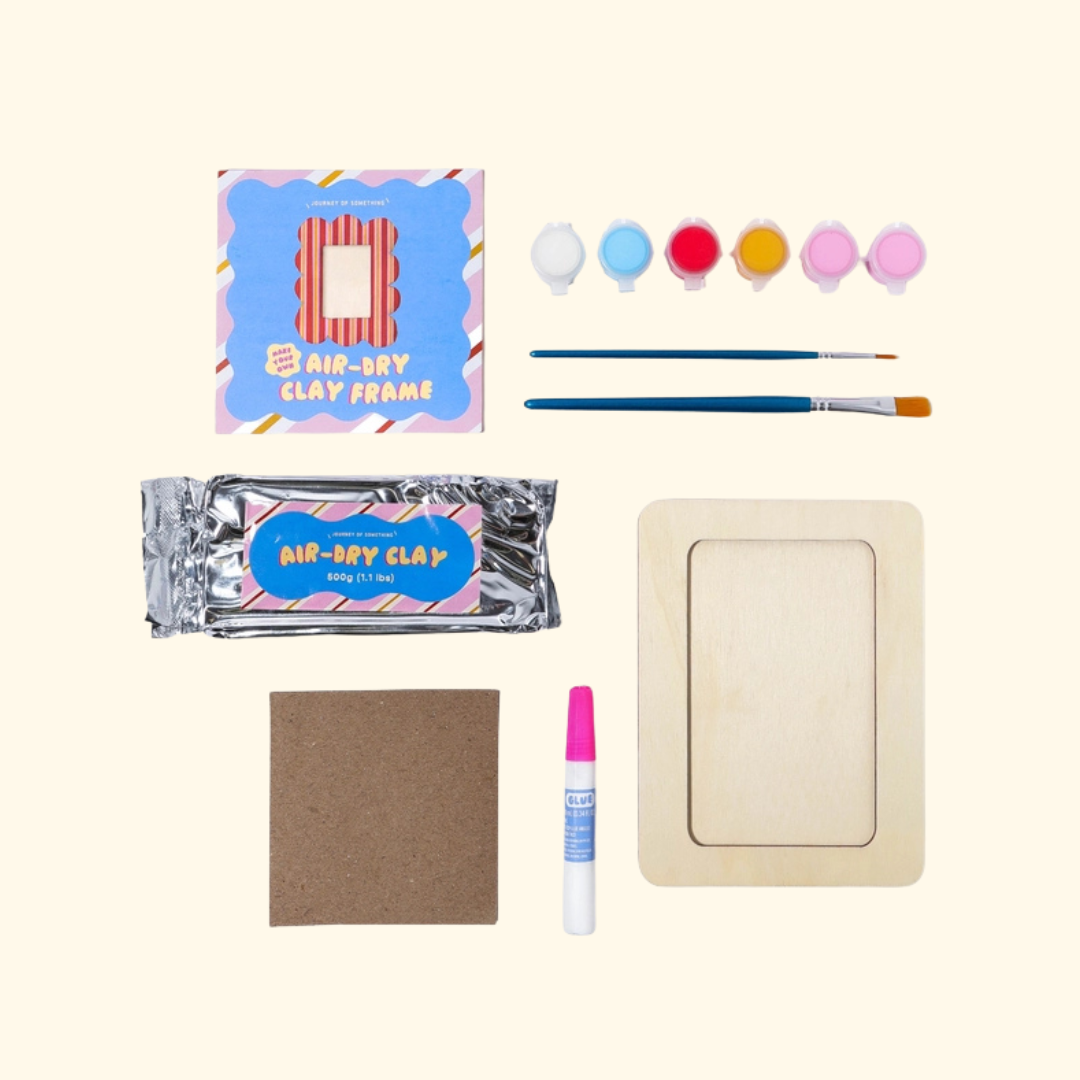 Contents of the Make Your Own Air Dry Clay Frame kit including air dry clay, frame, paint, paintbrush, tools and instructions.
