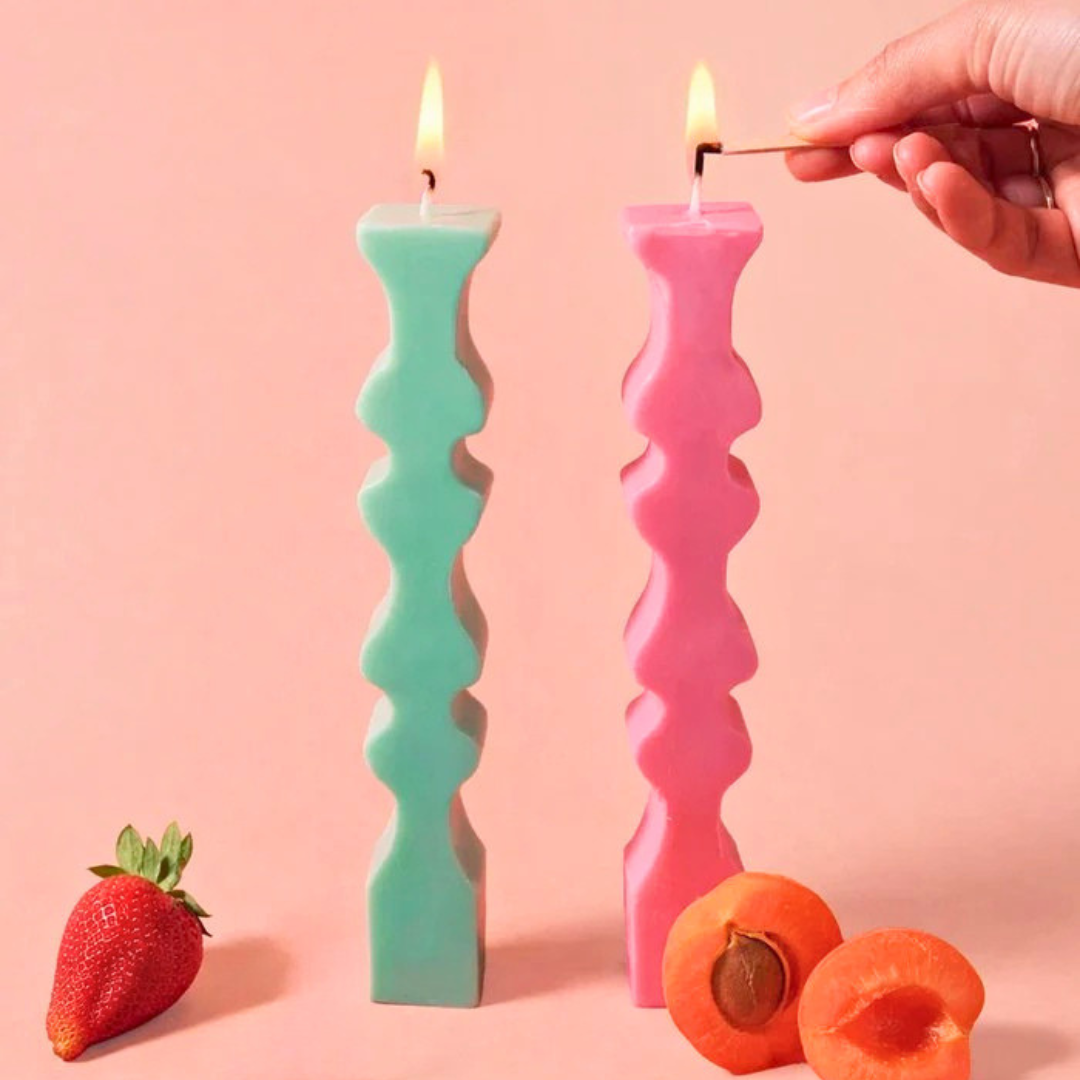 Finished decorative wavy candle sticks with lit candles.