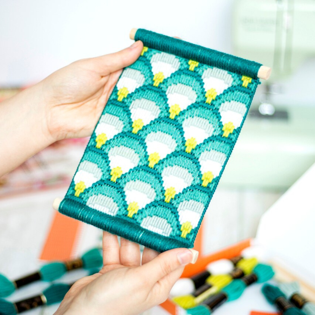 Hands stitching the Making Waves Bargello Wall Hanging Kit using colourful bargello embroidery techniques