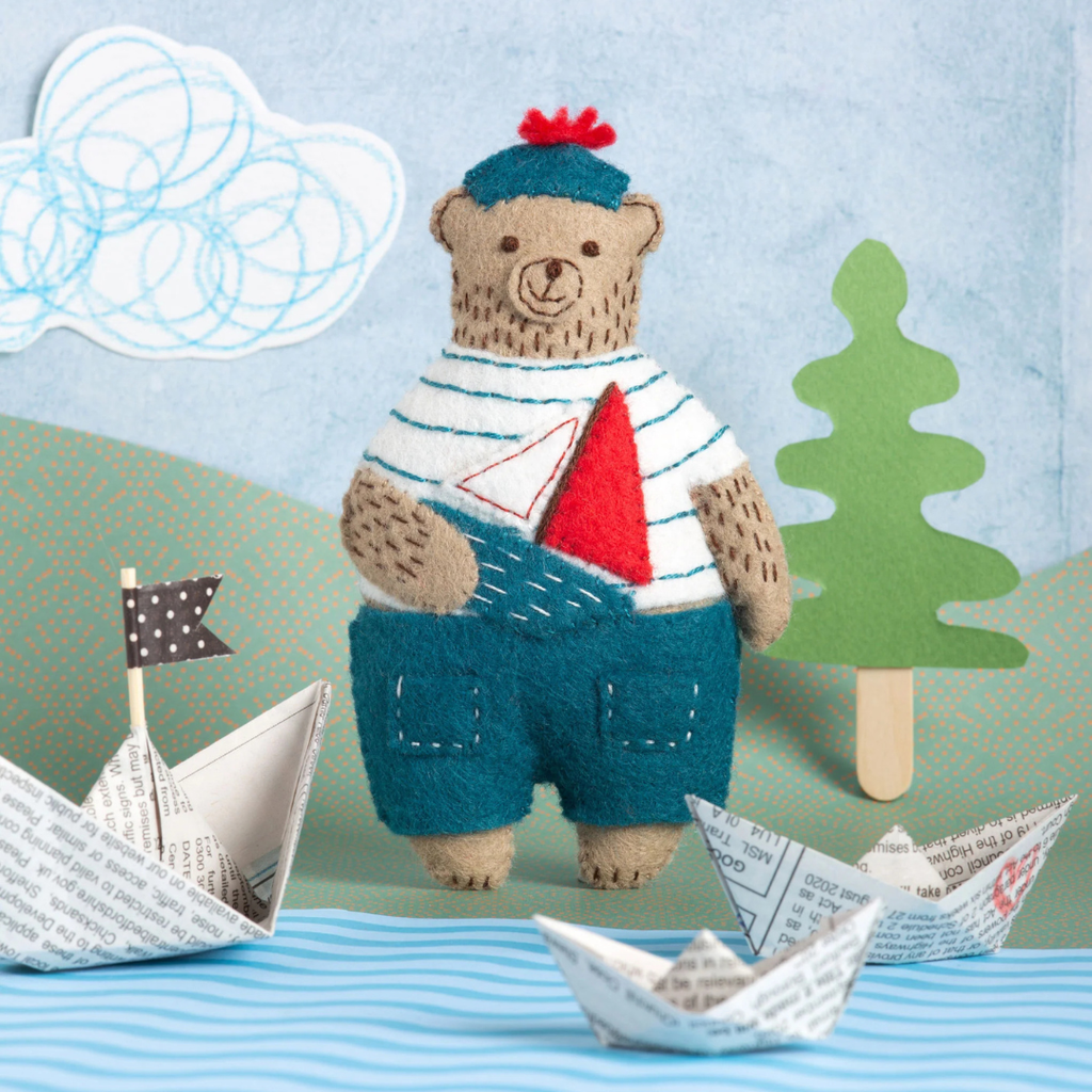 Finished Marcel the Sailor Bear felt craft kit by Corinne Lapierre styled with paper boats and nautical decorations.