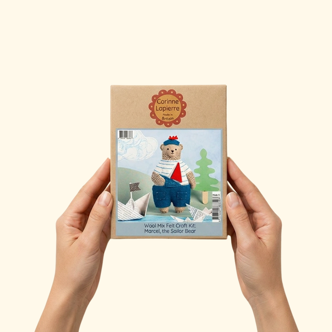 Person holding the Marcel the Sailor Bear felt craft kit packaging by Corinne Lapierre.