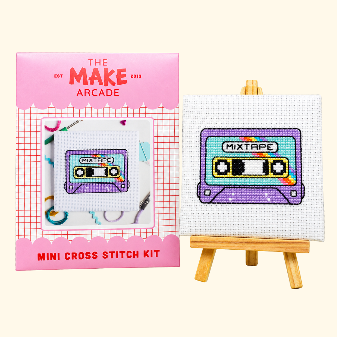 The Make Arcade Mixtape Mini Cross Stitch Kit beside the completed design on a miniature easel.