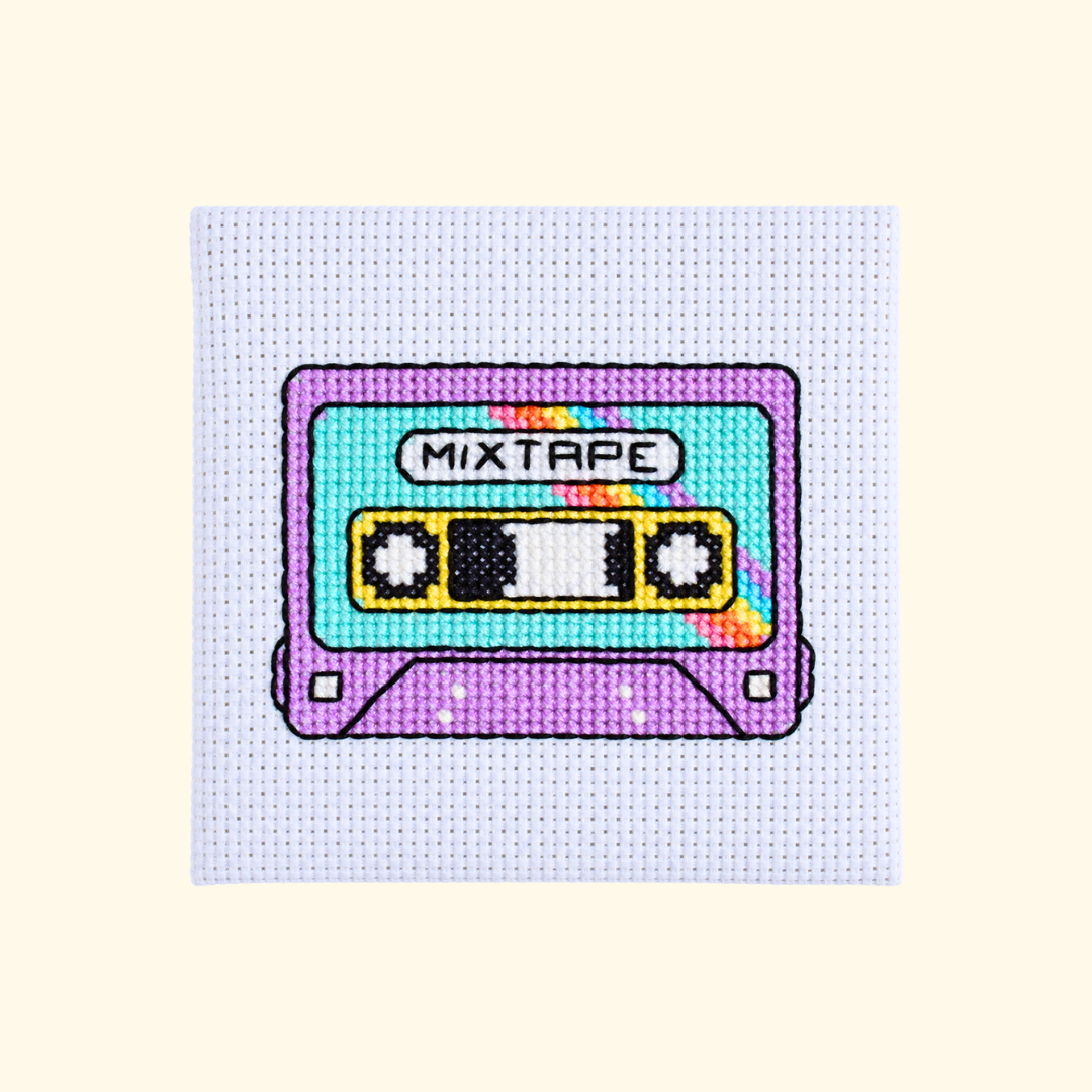 Completed colourful mixtape cassette cross stitch design on white Aida fabric.