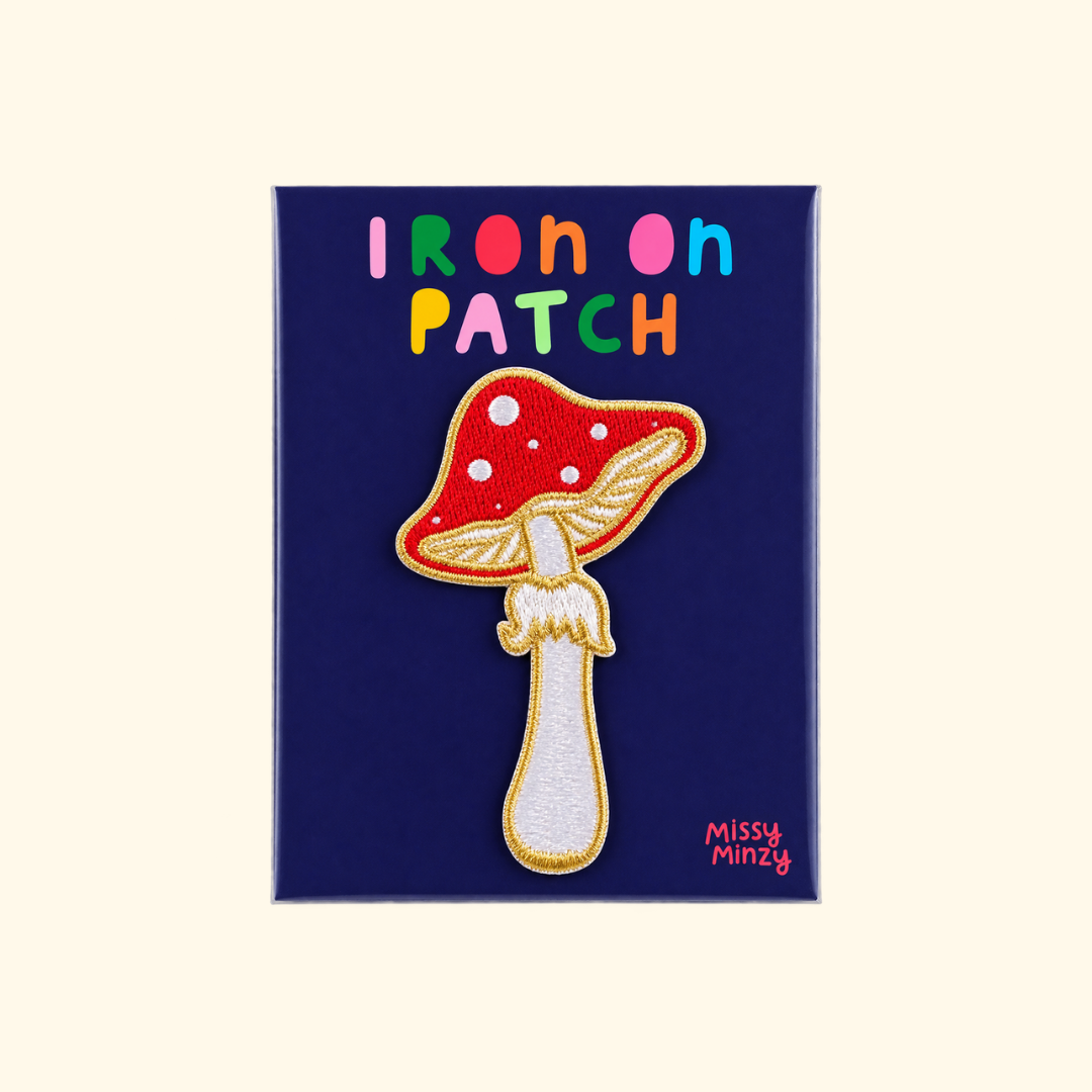 Mushroom embroidered iron on patch by Missy Minzy displayed on dark blue packaging.