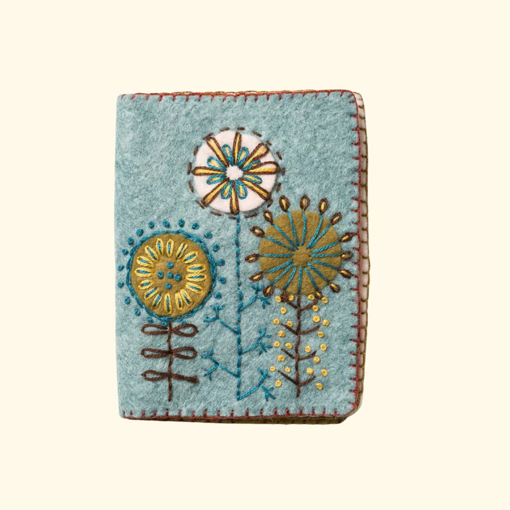 Completed blue felt needle case decorated with colourful embroidered flowers and blanket stitch edging.