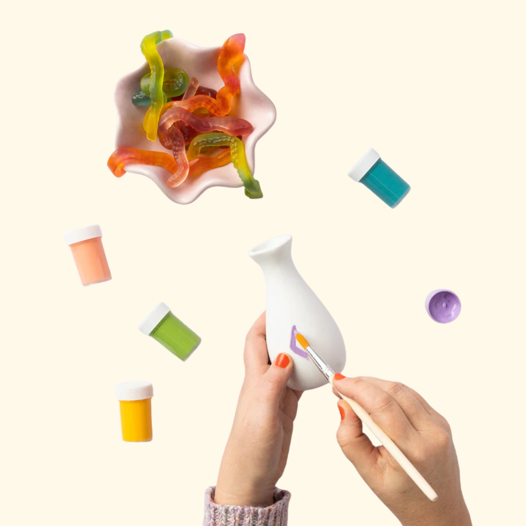 Decorating a ceramic vase with colourful paints from the Paint Your Own Vases Kit.