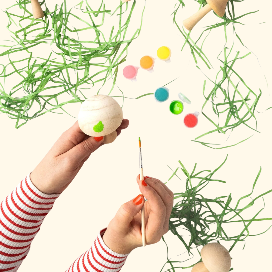Painting a wooden mushroom using the materials included in the Paint Your Wooden Mushrooms Kit.