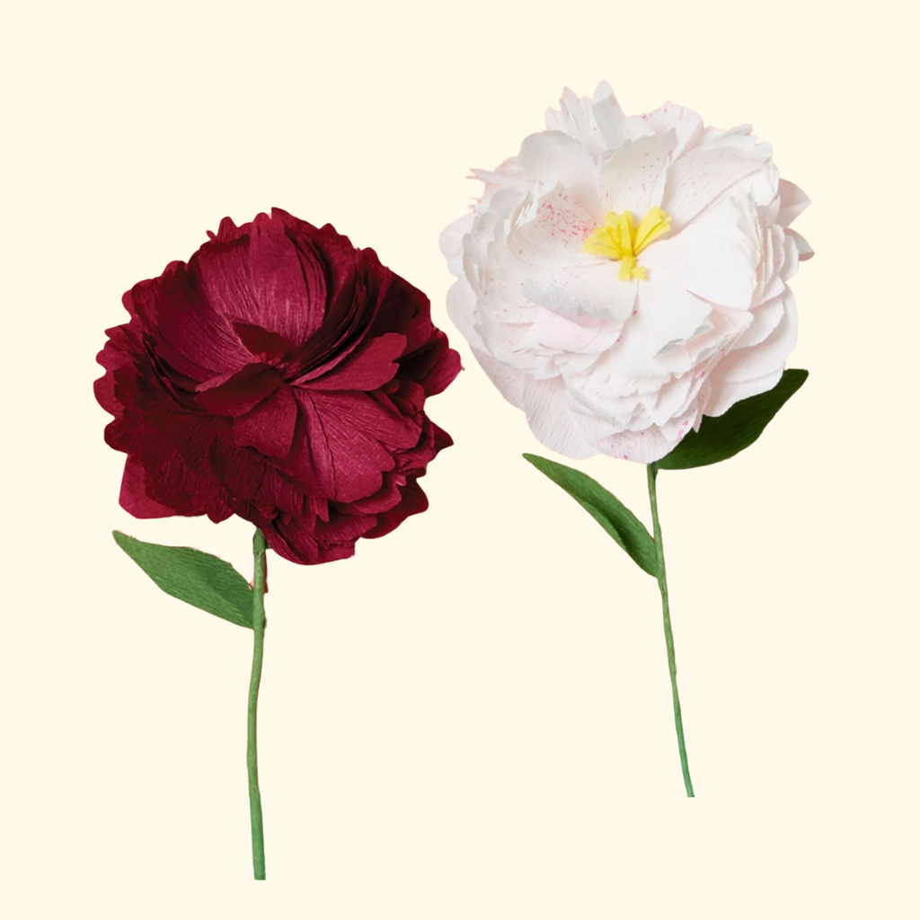 Handmade paper flower stems in red and white displayed against neutral background