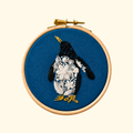 Completed Penguin Mini Embroidery Kit by Nest Embirdery featuring a hand-stitched penguin on navy fabric.