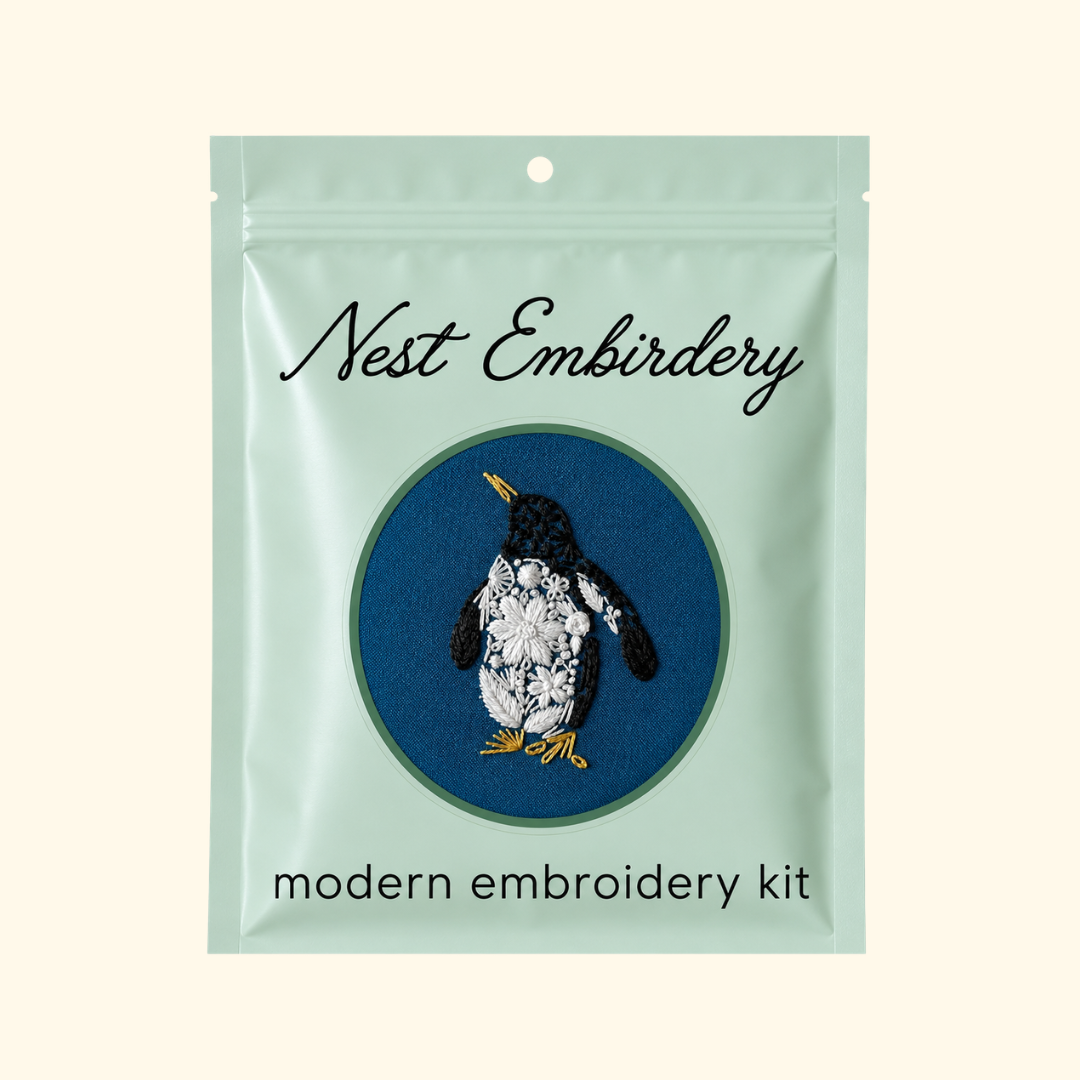 Nest Embirdery Penguin Mini Embroidery Kit in illustrated green packaging.