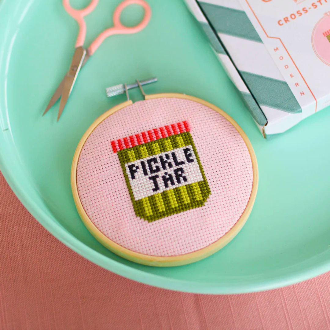 Finished pickle jar cross stitch displayed in a bamboo embroidery hoop.