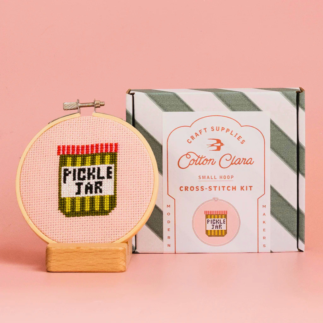Cotton Clara Pickle Jar Cross Stitch Kit displayed with the finished cross stitch and gift box.