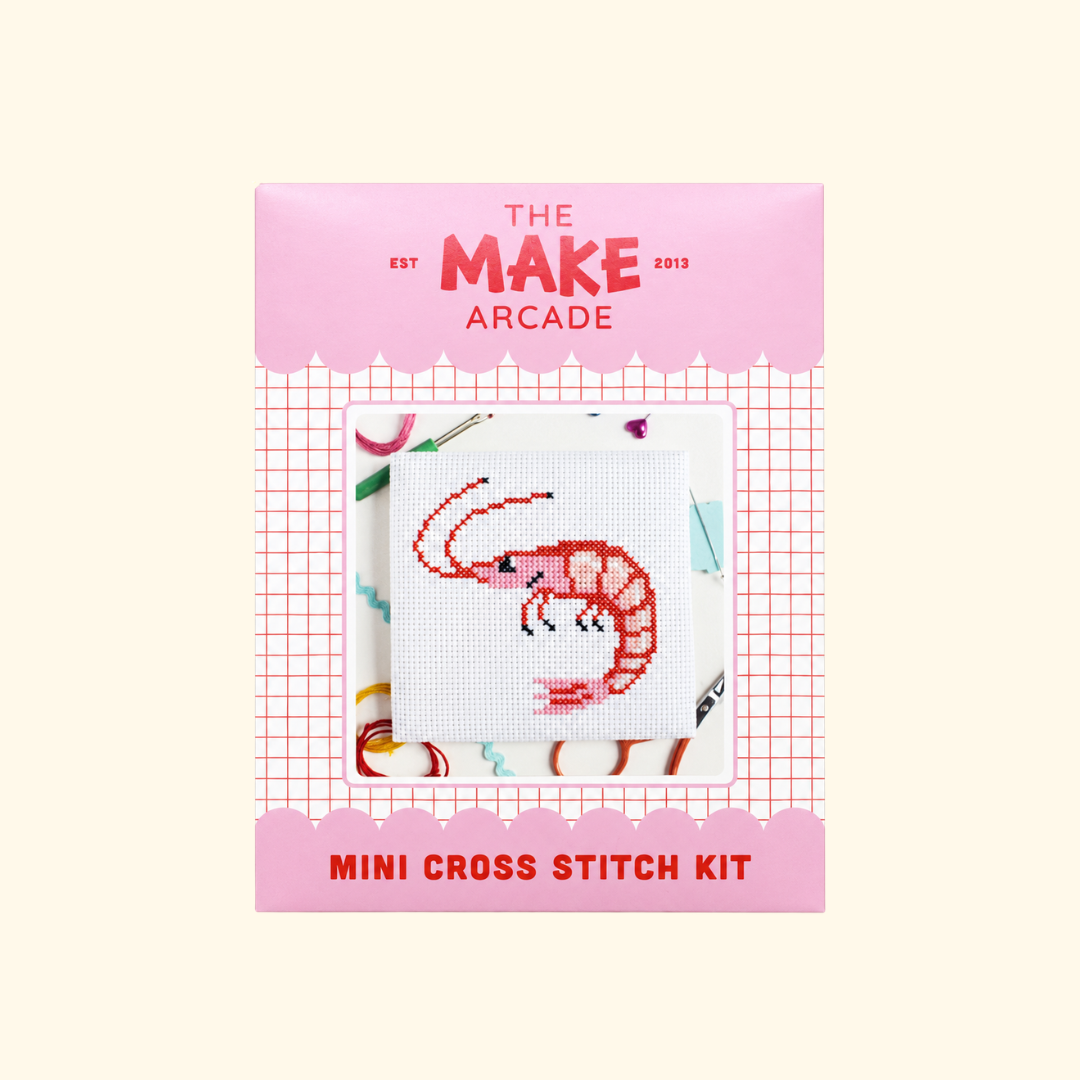The Make Arcade Prawn Mini Cross Stitch Kit in pink recyclable packaging.