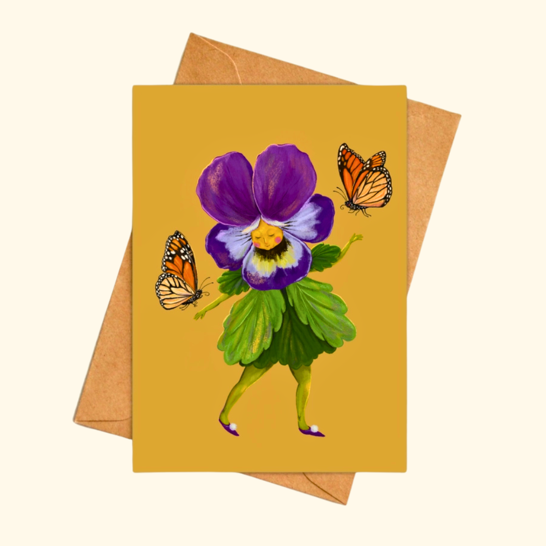 Pretty Pansy greeting card shown with a matching kraft envelope, featuring an illustrated pansy flower in boots surrounded by fluttering butterflies.
