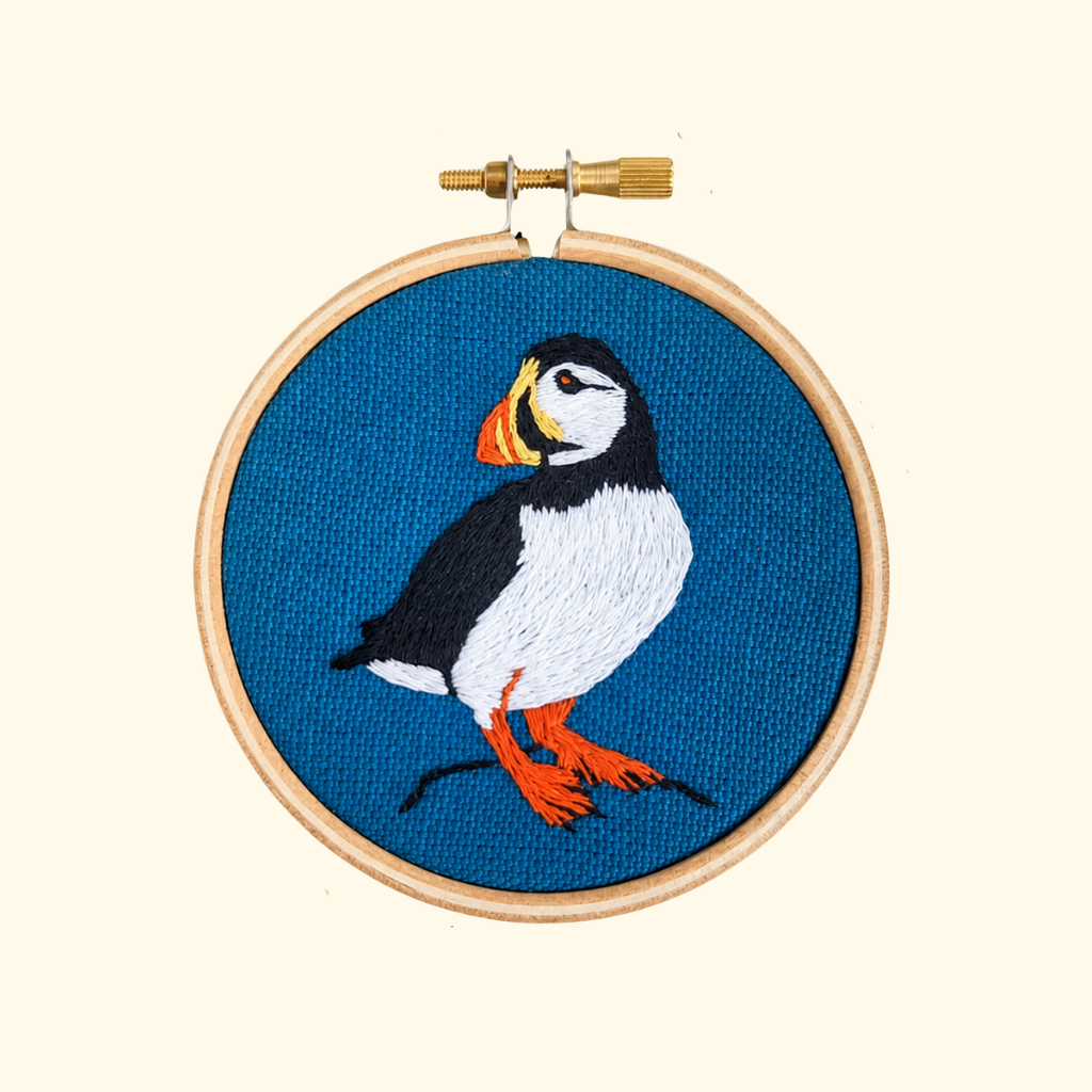 Finished Puffin Mini Embroidery Kit by Paraffle displayed in a wooden embroidery hoop.