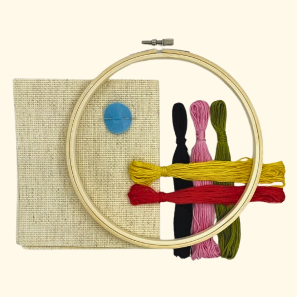 Queen of Hearts Cross Stitch Kit by Budgiegoods with wooden hoop, cream Aida fabric, threads and needle.