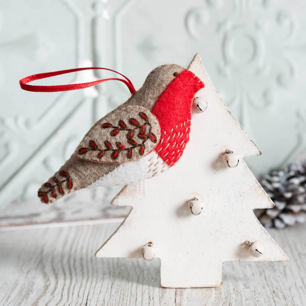 Finished Red Robin felt craft kit by Corinne Lapierre displayed on a star shaped decoration in a styled setting.