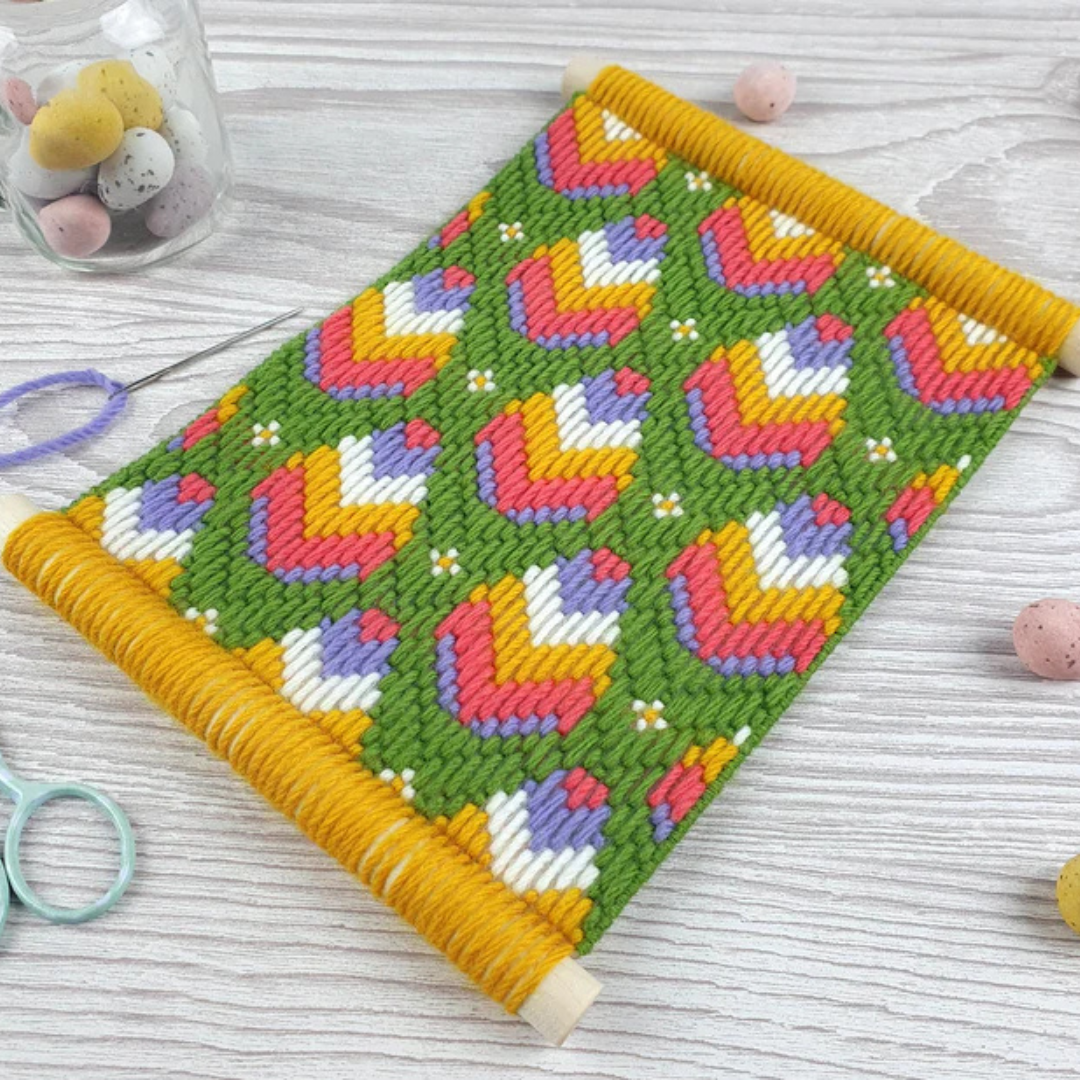 Retro Blooms Bargello Wall Hanging Kit displayed in a crafting workspace with tapestry wool and stitching supplies