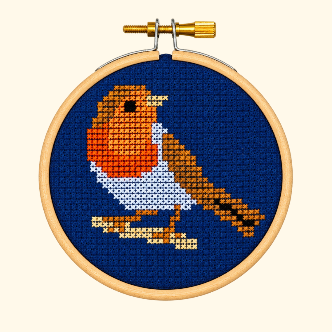 Finished Robin Redbreast Mini Cross Stitch Kit by Paraffle featuring an orange-breasted robin on a deep blue background in a wooden hoop.