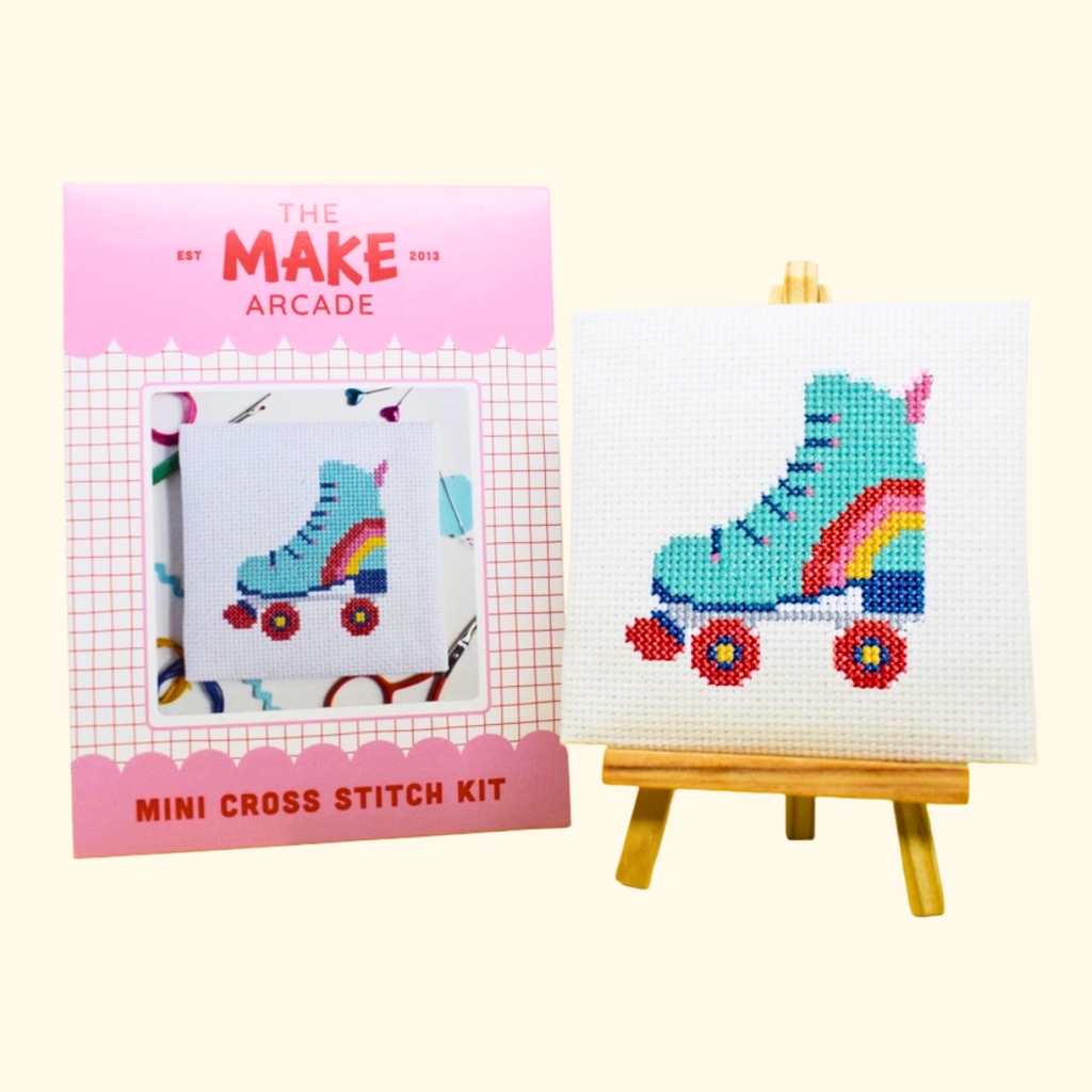 Roller Derby Mini Cross Stitch Kit by The Make Arcade with packaging and finished stitched design on a mini easel.