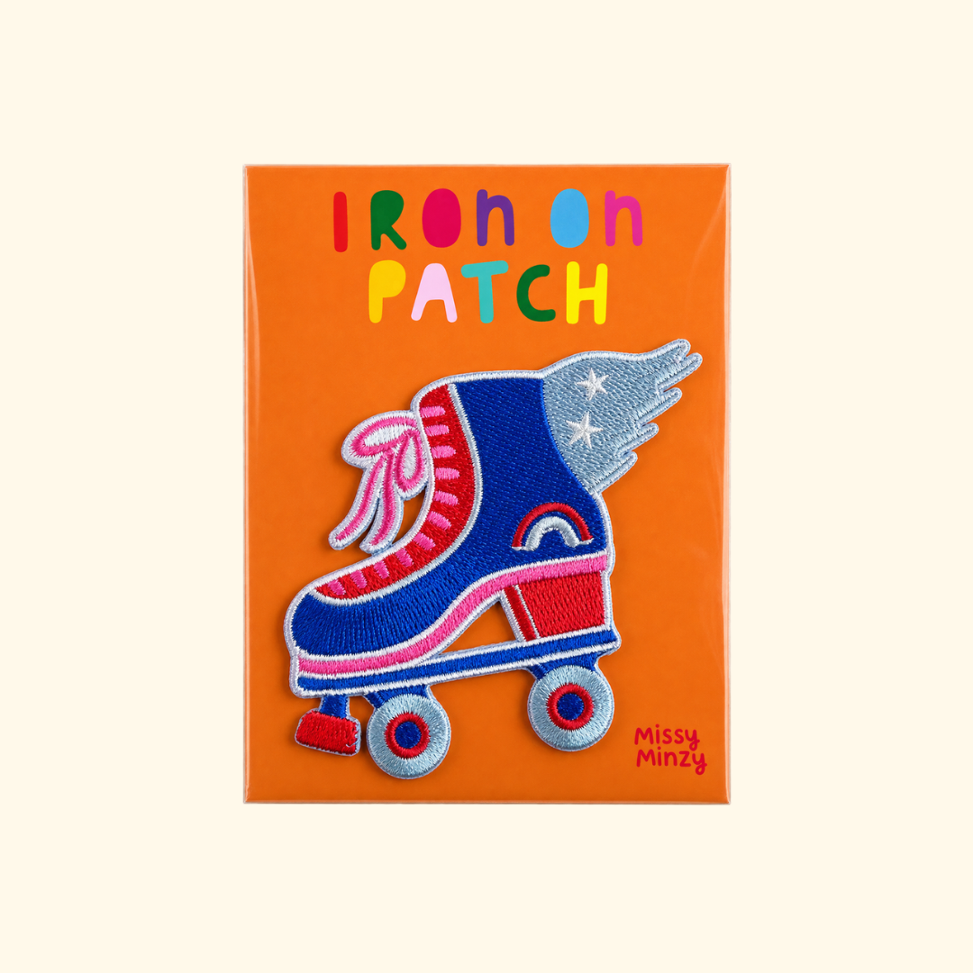 Roller skate embroidered iron on patch by Missy Minzy displayed on bright orange packaging.