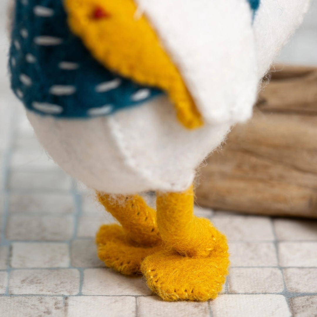 Close-up of the finished Sam the Seagull felt craft kit showing the stitched yellow feet and lower body.