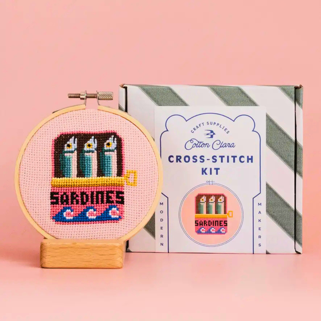 Cotton Clara Sardines Cross Stitch Kit displayed with the finished cross stitch and gift box.