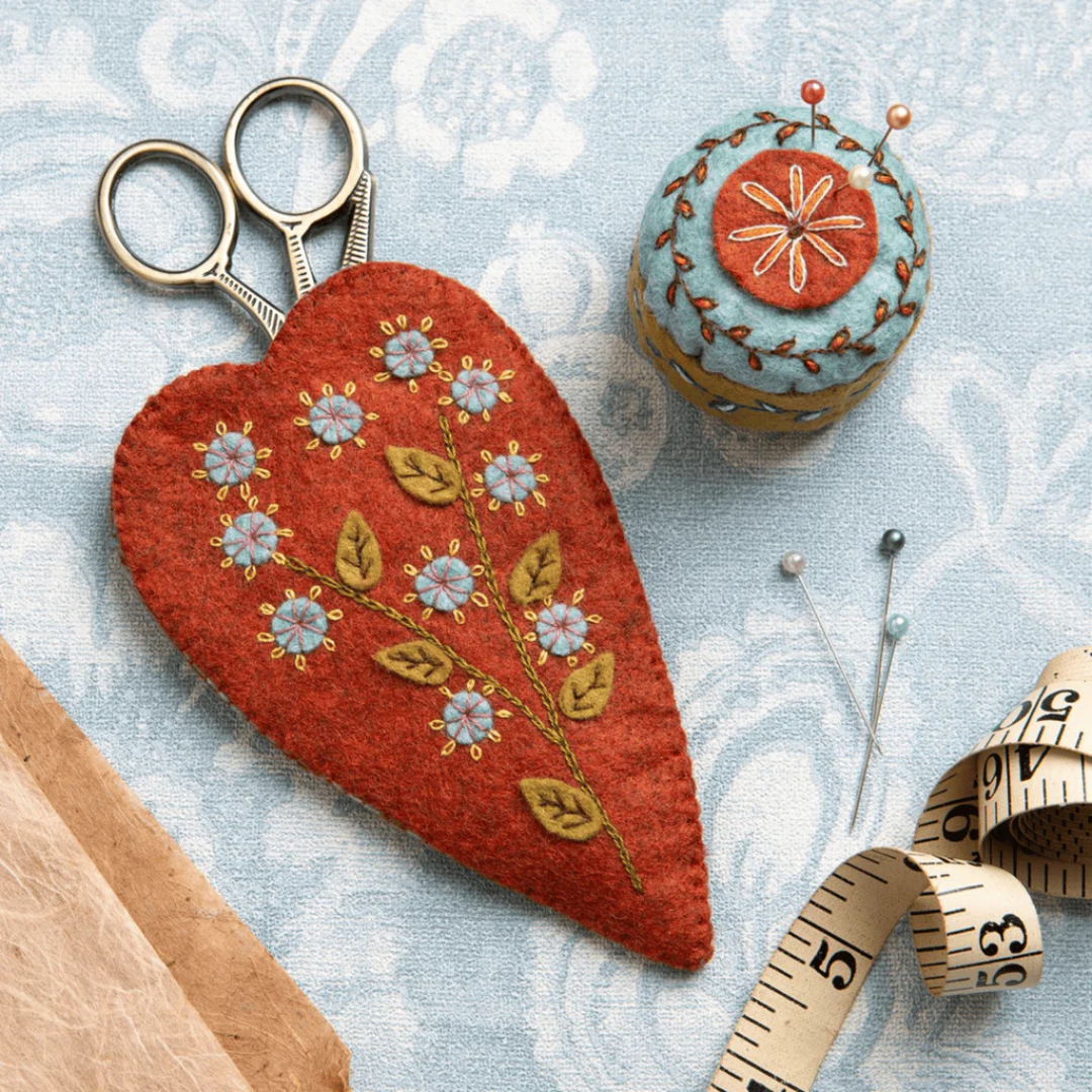 Finished embroidered scissors pouch and matching pincushion displayed with scissors and sewing accessories