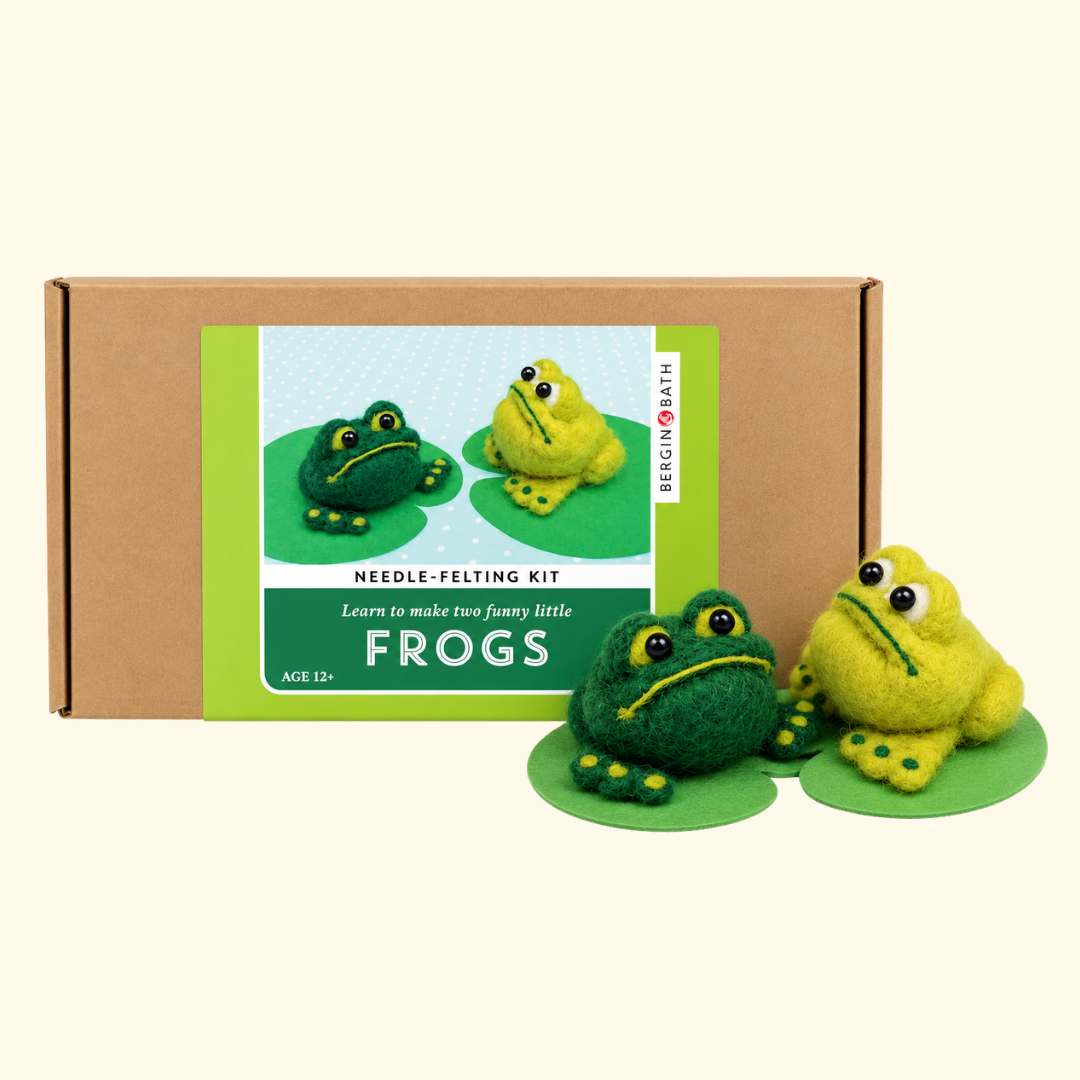 Bergin And Bath Set Of 2 Frogs Needle Felting Kit packaging displayed alongside two finished green wool frogs with playful expressions.