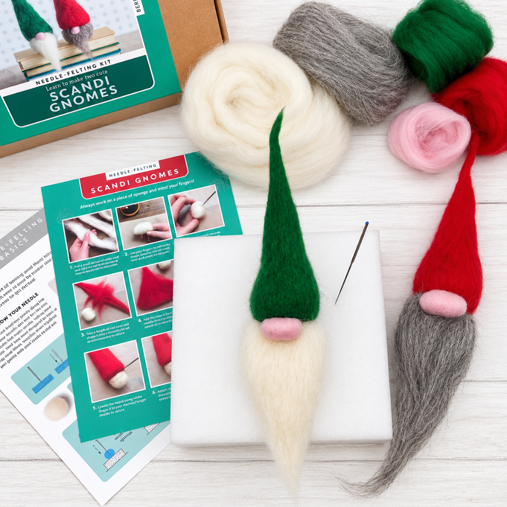 Red and green Scandinavian wool gnomes displayed with colourful wool fibres, a felting needle and illustrated instructions from the Bergin And Bath craft kit.