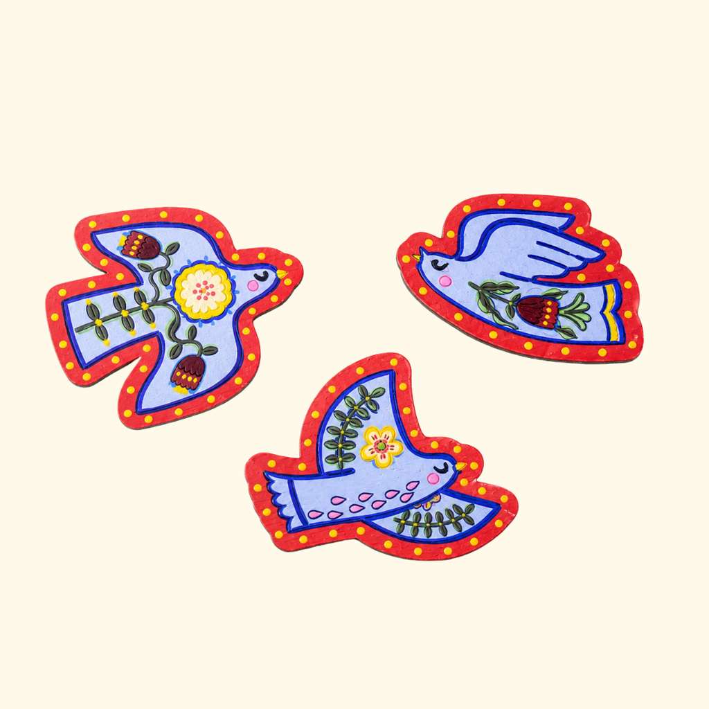 Set of three finished folk bird magnets painted in bright red, blue and white acrylic paints.