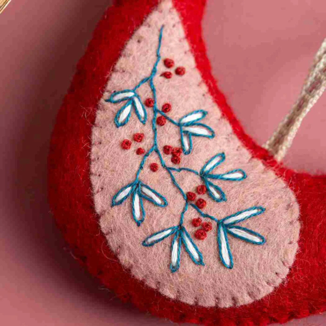 Close up of embroidered floral stitching detail on a felt bird from the Set Of 5 Folk Birds Felt Craft Kit by Corinne Lapierre.