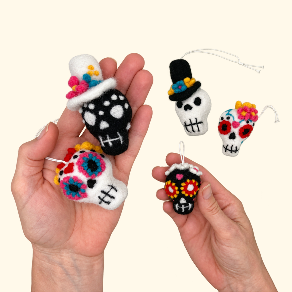 Five finished needle felted sugar skull decorations held in two hands