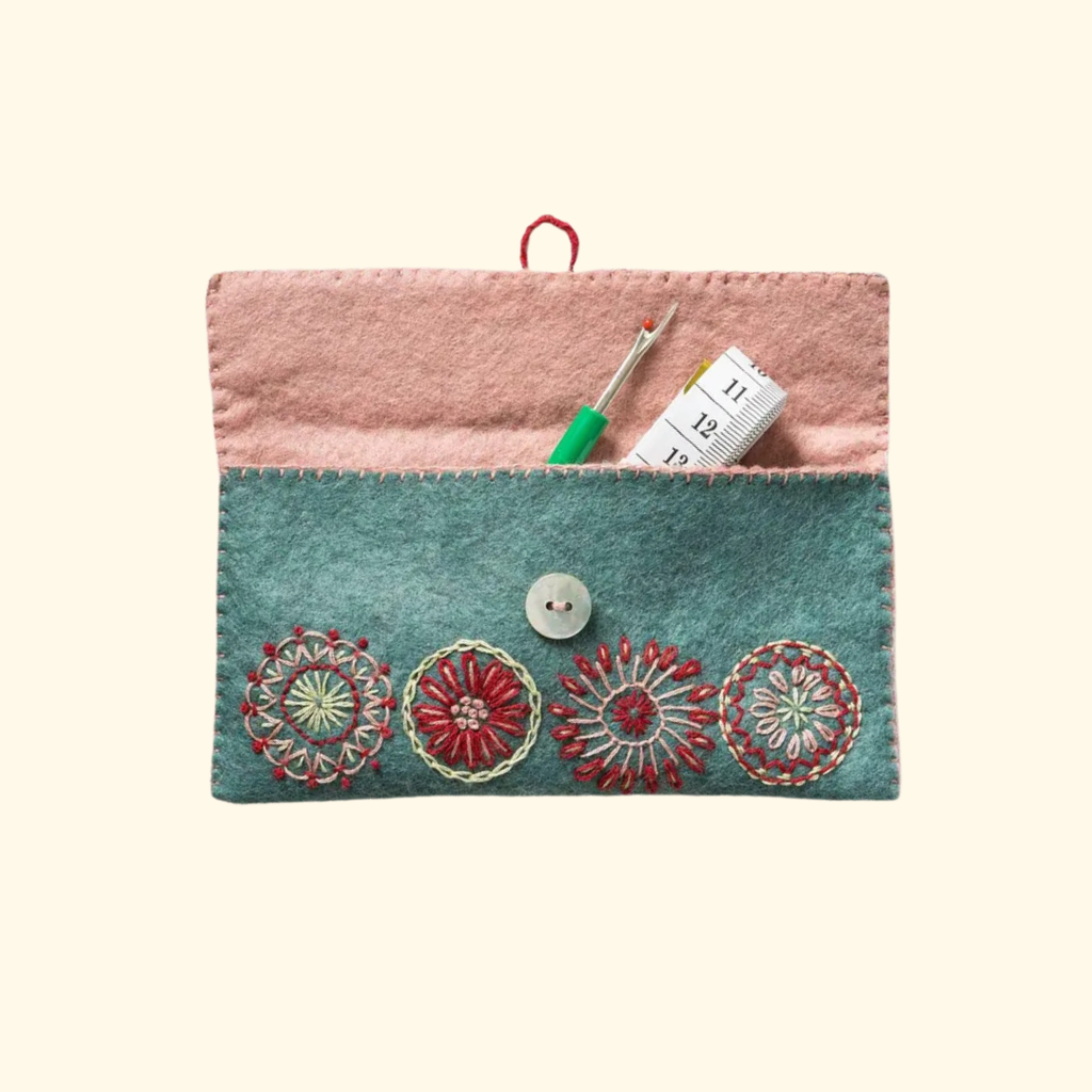 Handmade felt sewing pouch shown open with sewing accessories stored inside