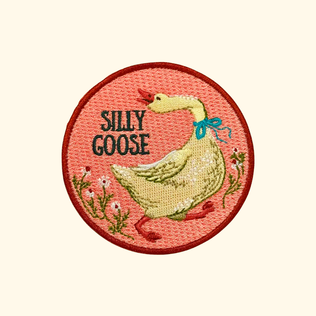 Silly Goose iron on embroidered patch by Anna Seed Art featuring a goose with floral details on a pink background.