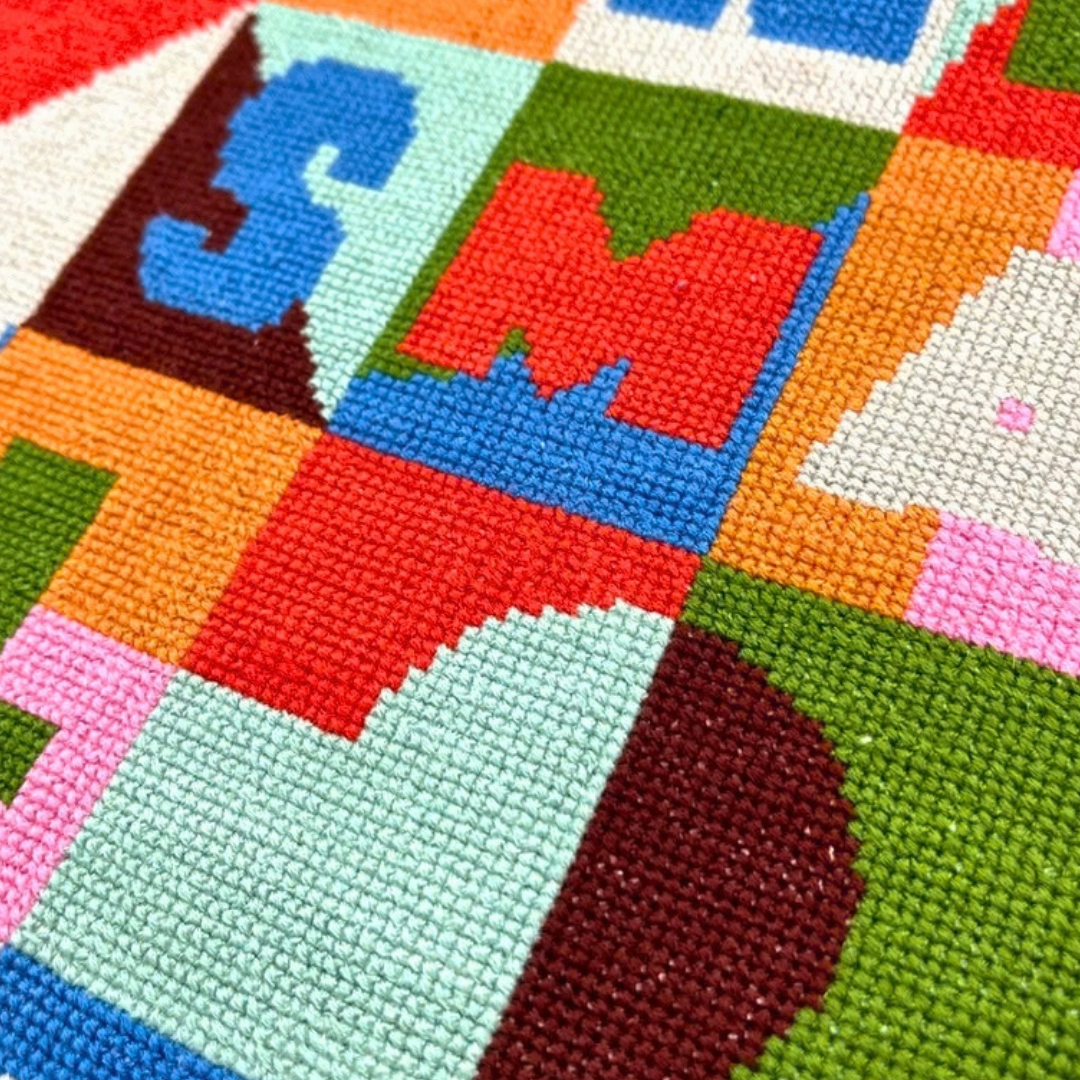 Close-up of the Small Joys cross stitch by Budgiegoods, showing colourful geometric stitching and textured details.