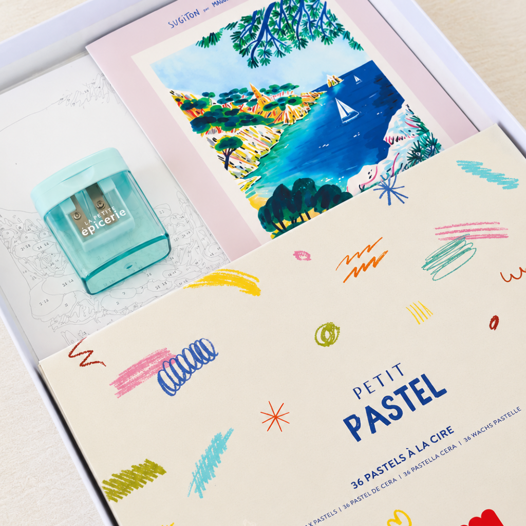 Sugiton Cove Pastels By Numbers Kit by La Petite Epicerie showing the coastal artwork, colourful wax pastels, sharpener and accompanying materials.