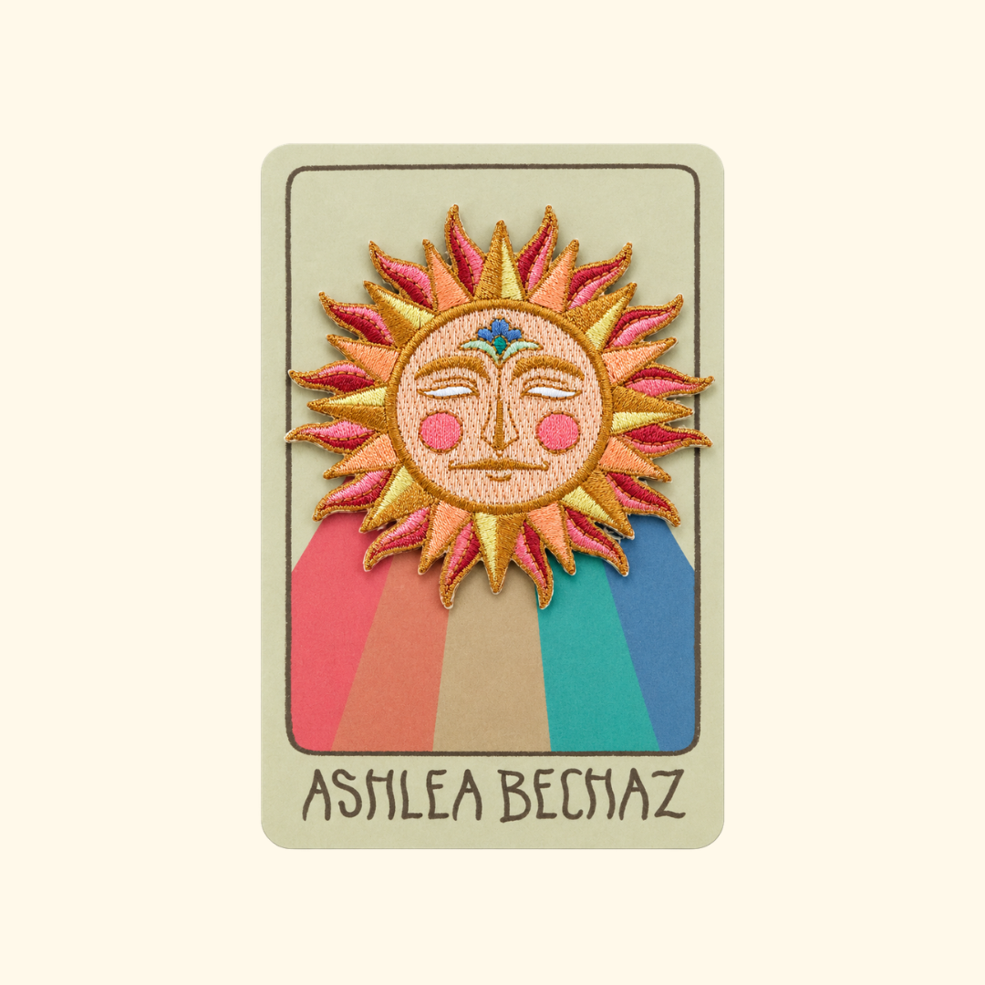 Sun Embroidered Iron On Patch by Ashlea Bechaz Illustration displayed on illustrated backing card against a cream background.