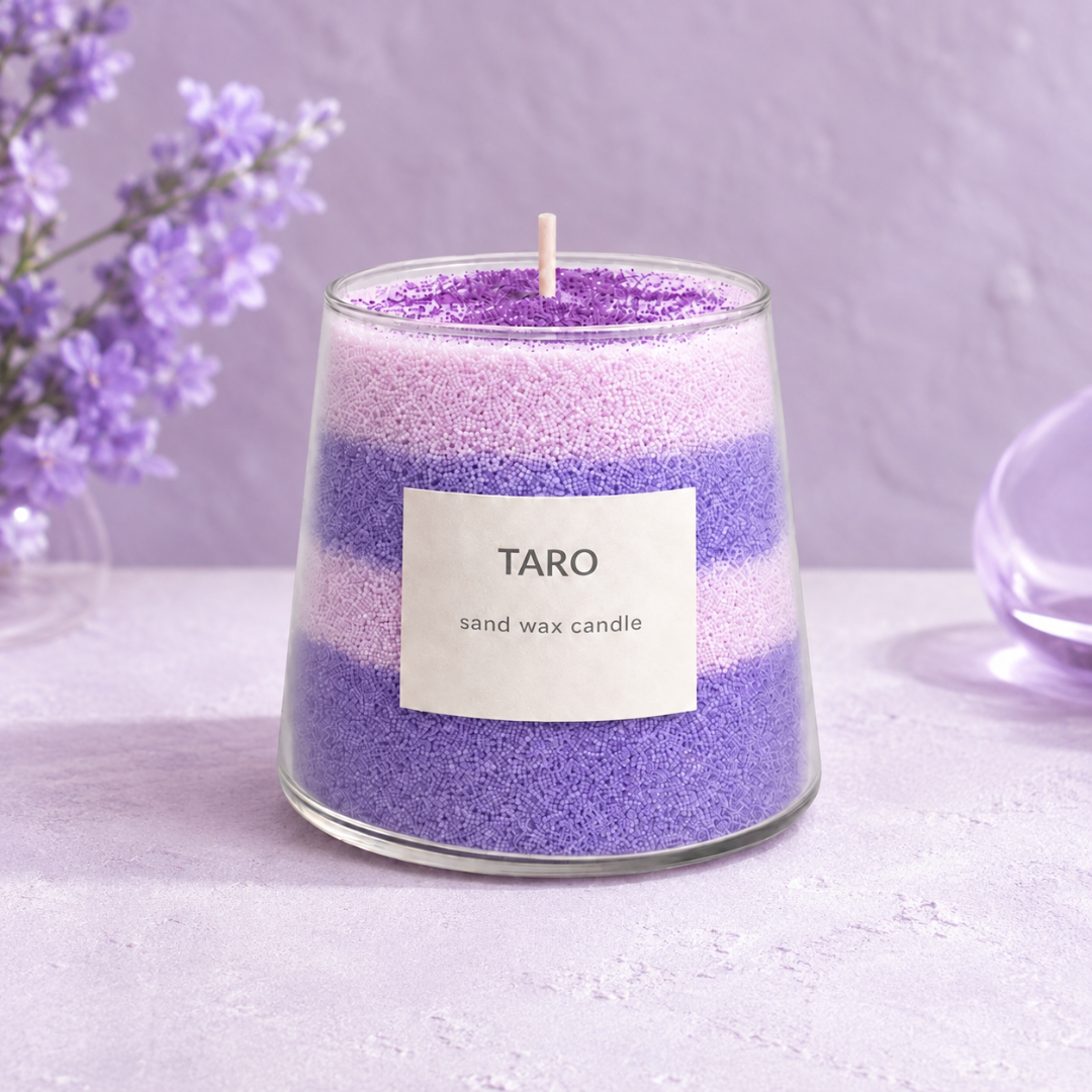 Finished purple Taro Dream sand candle made with the Aurea Nova DIY candle kit, styled with lilac flowers.