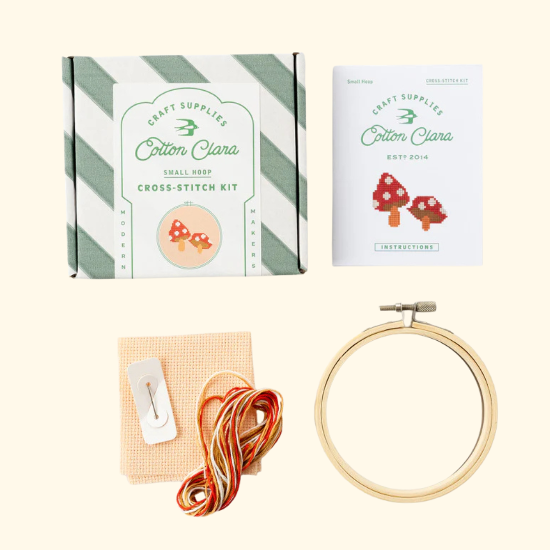 Contents of the Cotton Clara Toadstools Cross Stitch Kit including hoop, Aida fabric, threads, needle and instructions.