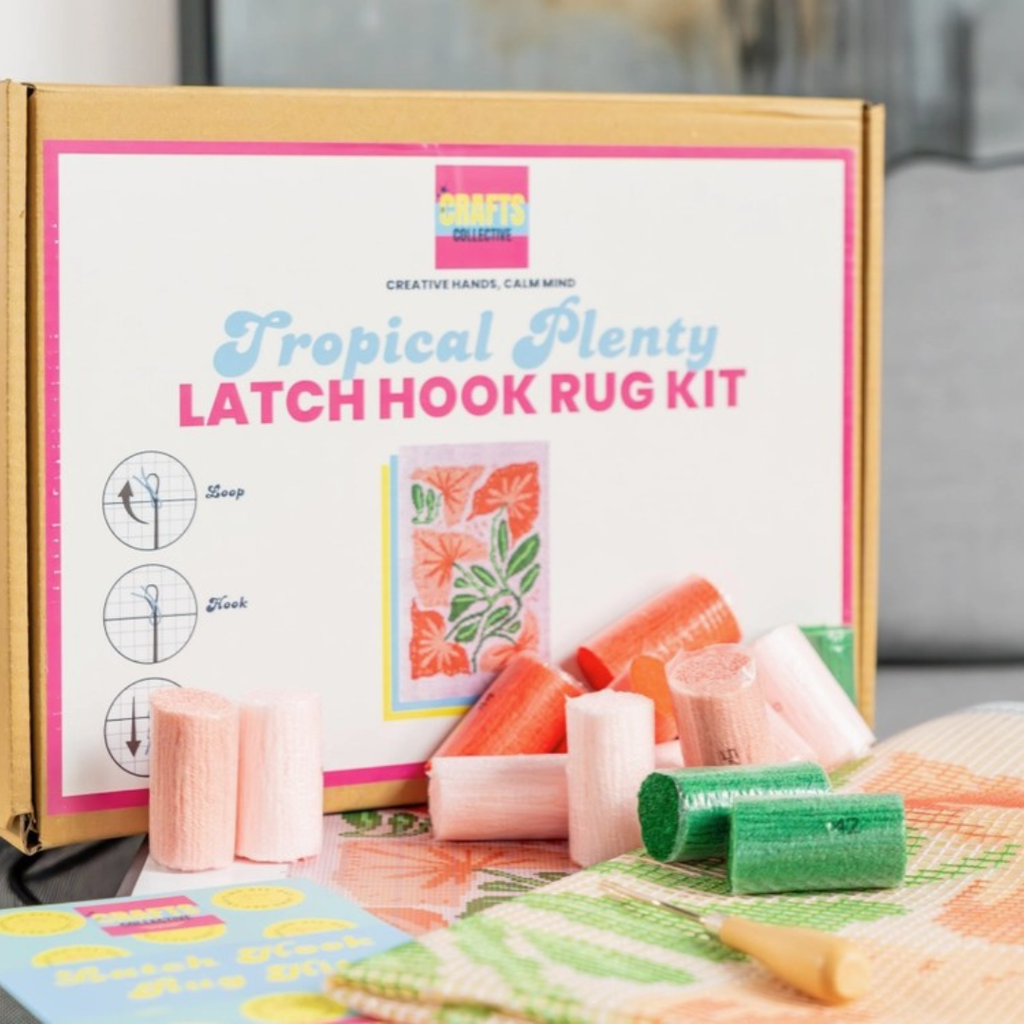 Tropical Plenty rug hooking kit displayed with crafting tools, materials and packaging ready for a creative project.