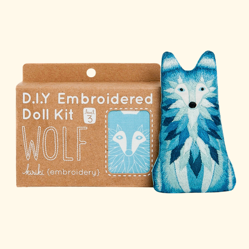 Wolf Embroidery Kit by Kiriki Press shown with the completed embroidered doll and packaging.