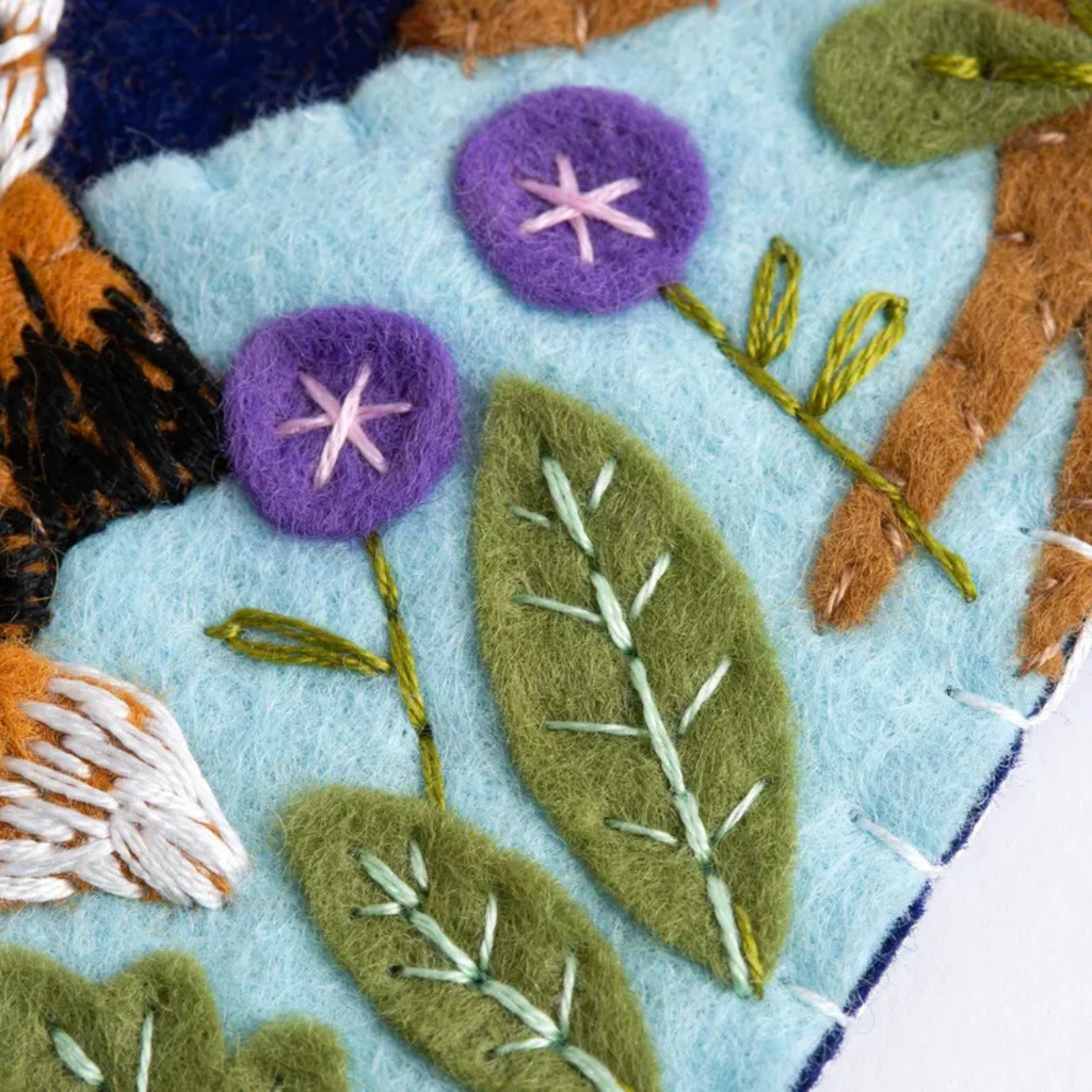 Close up of embroidered felt flowers and leaves on the woodland wall hanging