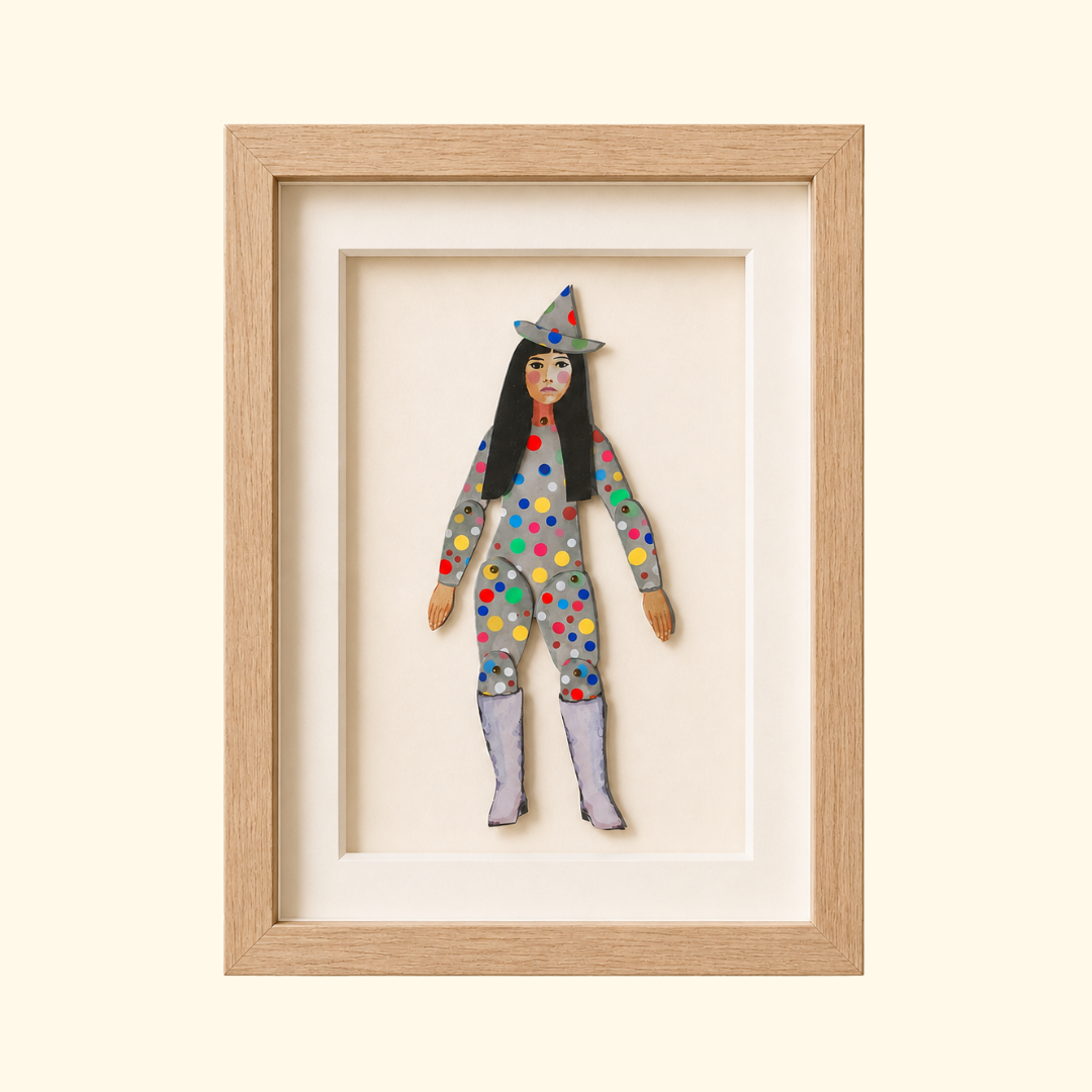 Yayoi Kusama paper puppet by Wini Tapp displayed finished in a wooden frame